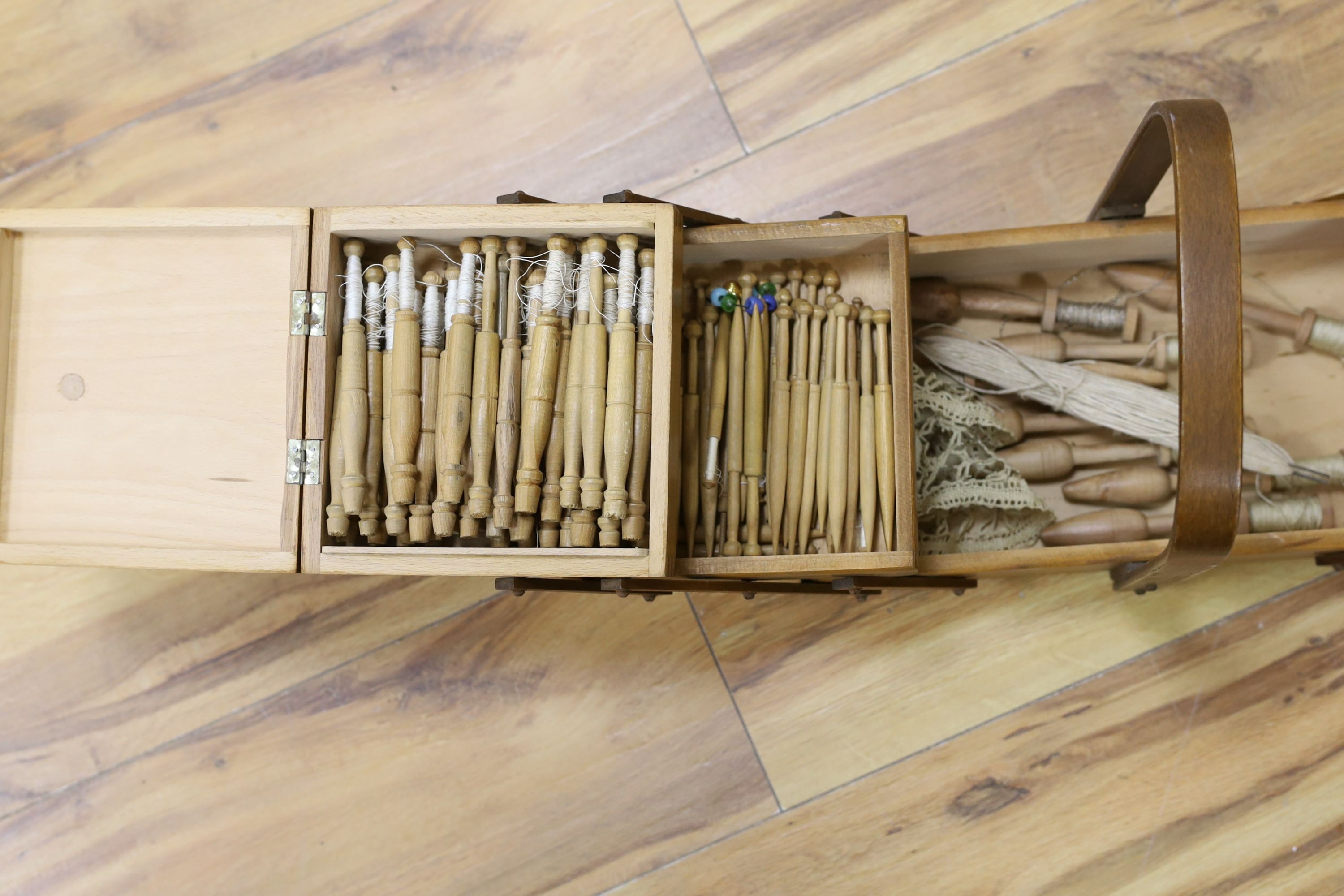 A collection of lace maker's bobbins, cast silver lace-maker under glass dome, related copper wall plate, figures and prints